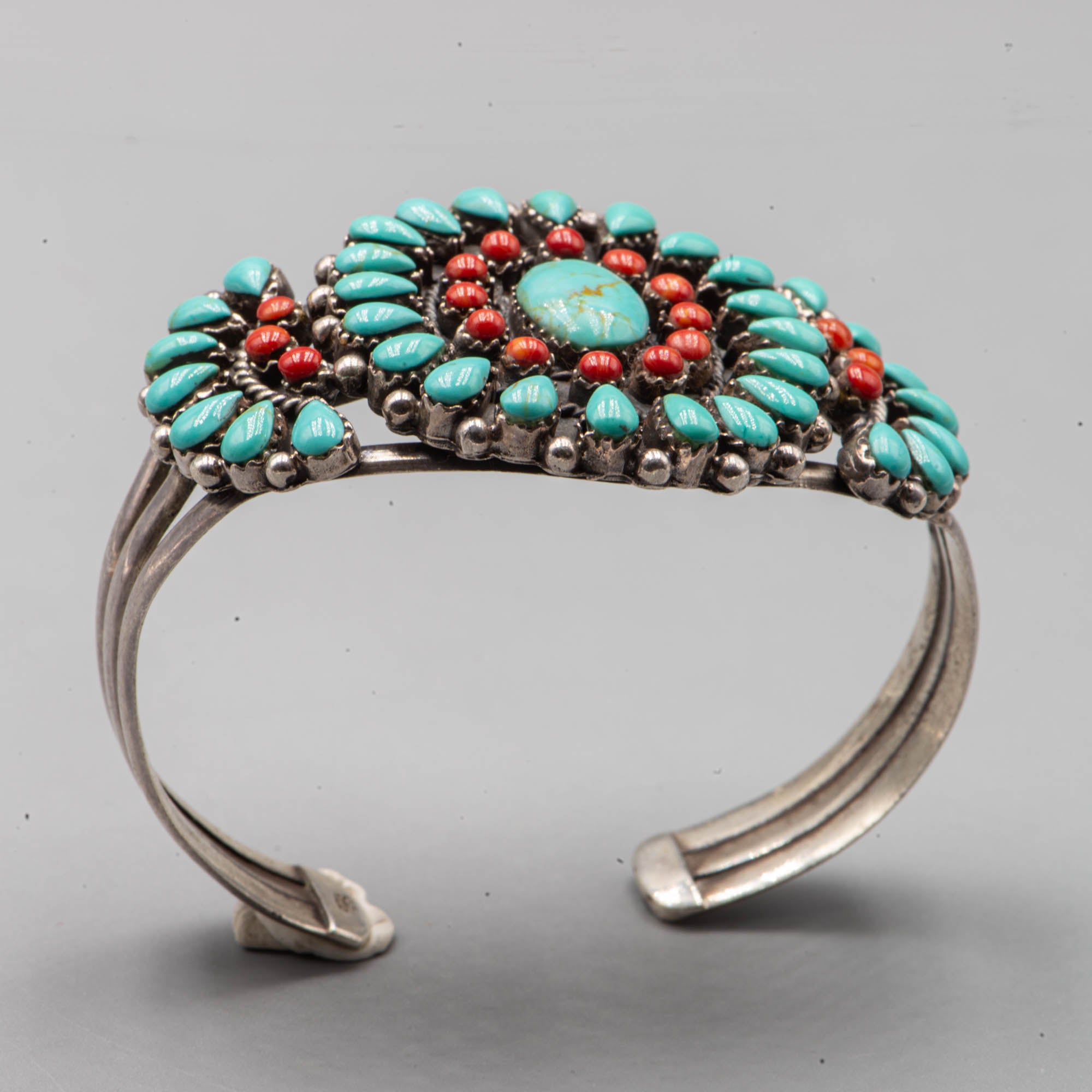 Native American silver cuff adorned with turquoise cabochon and coral cabochon