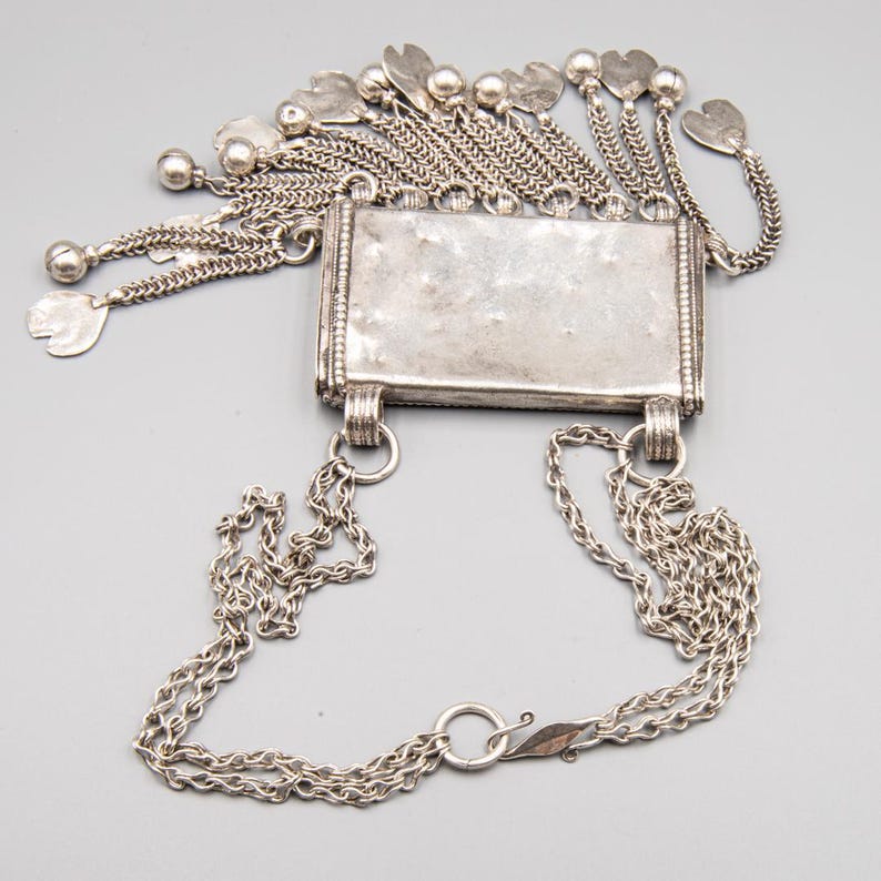 Detail of double silver chain and amulet construction