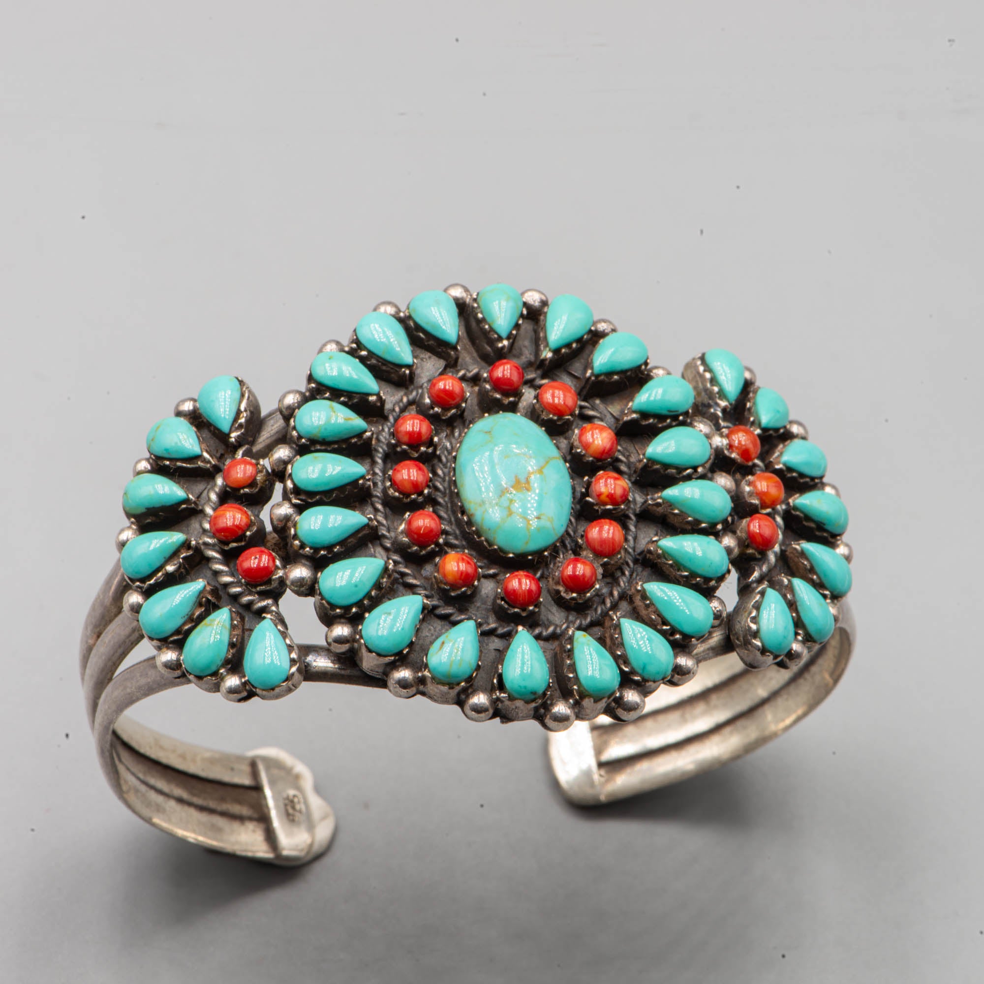 Native American silver cuff adorned with turquoise cabochon and coral cabochon