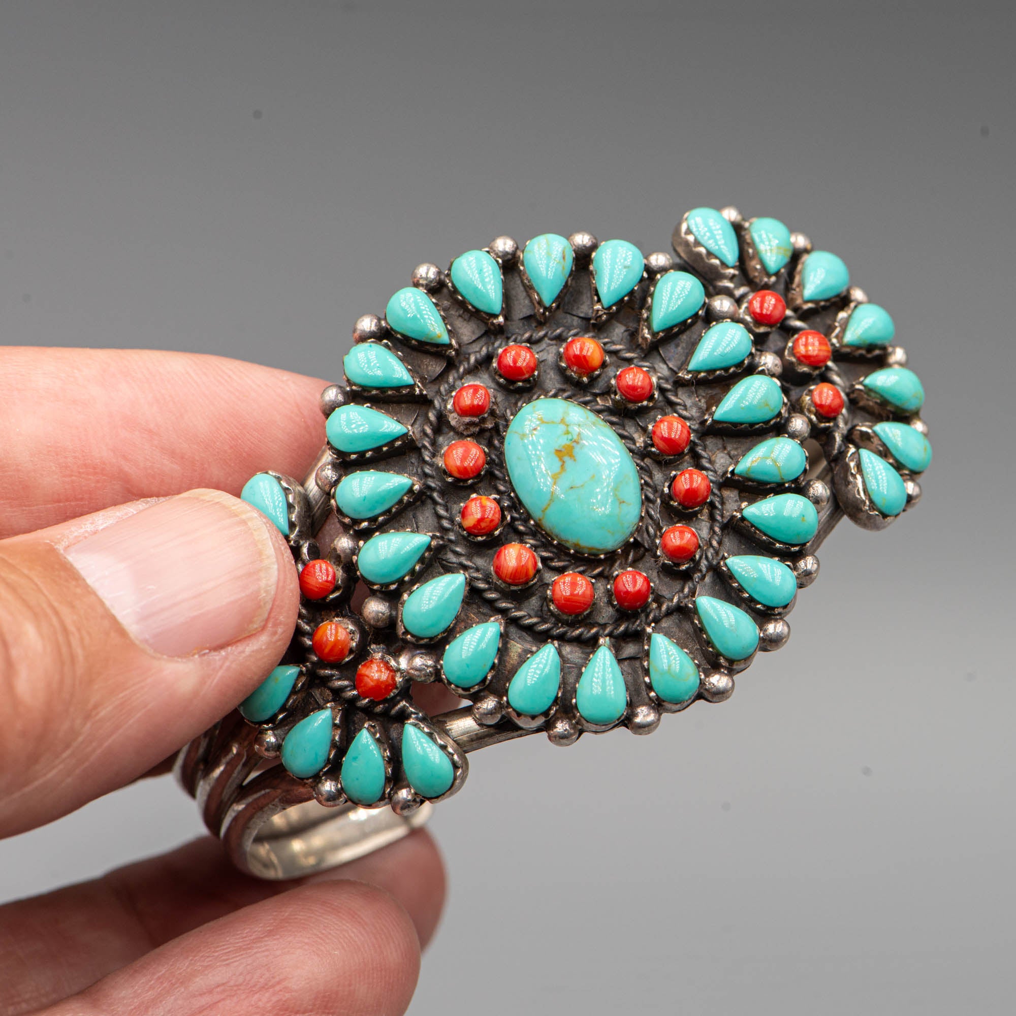 Native American silver cuff adorned with turquoise cabochon and coral cabochon